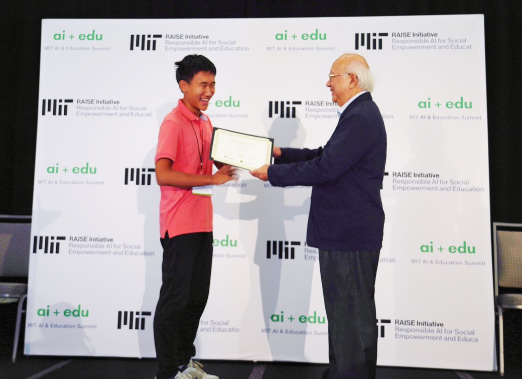 A student receiving an award certificate at the MIT AI + Education Summit