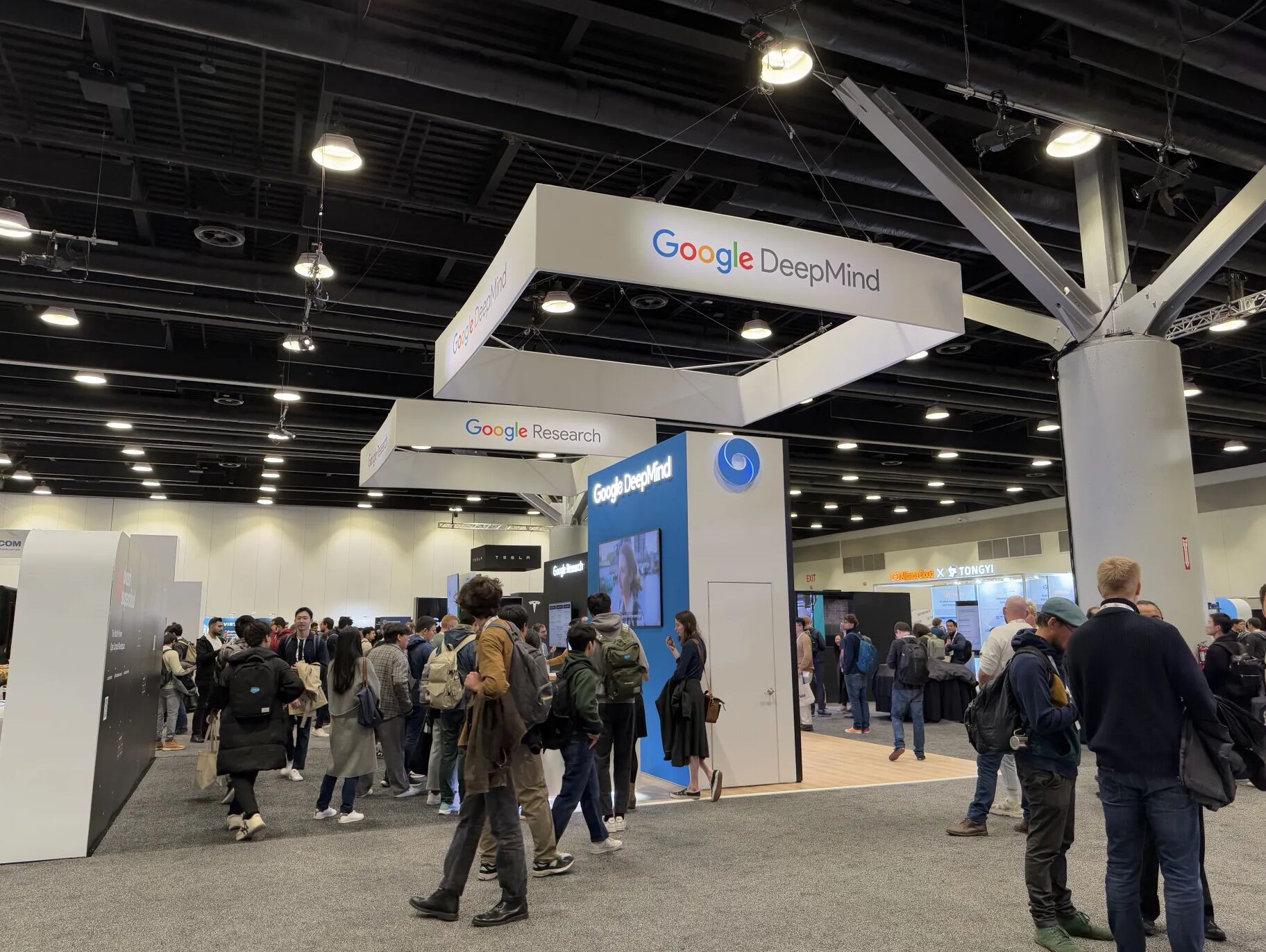 Attendees visiting the Google DeepMind and Google Research exhibition booths at ICLR 2025.