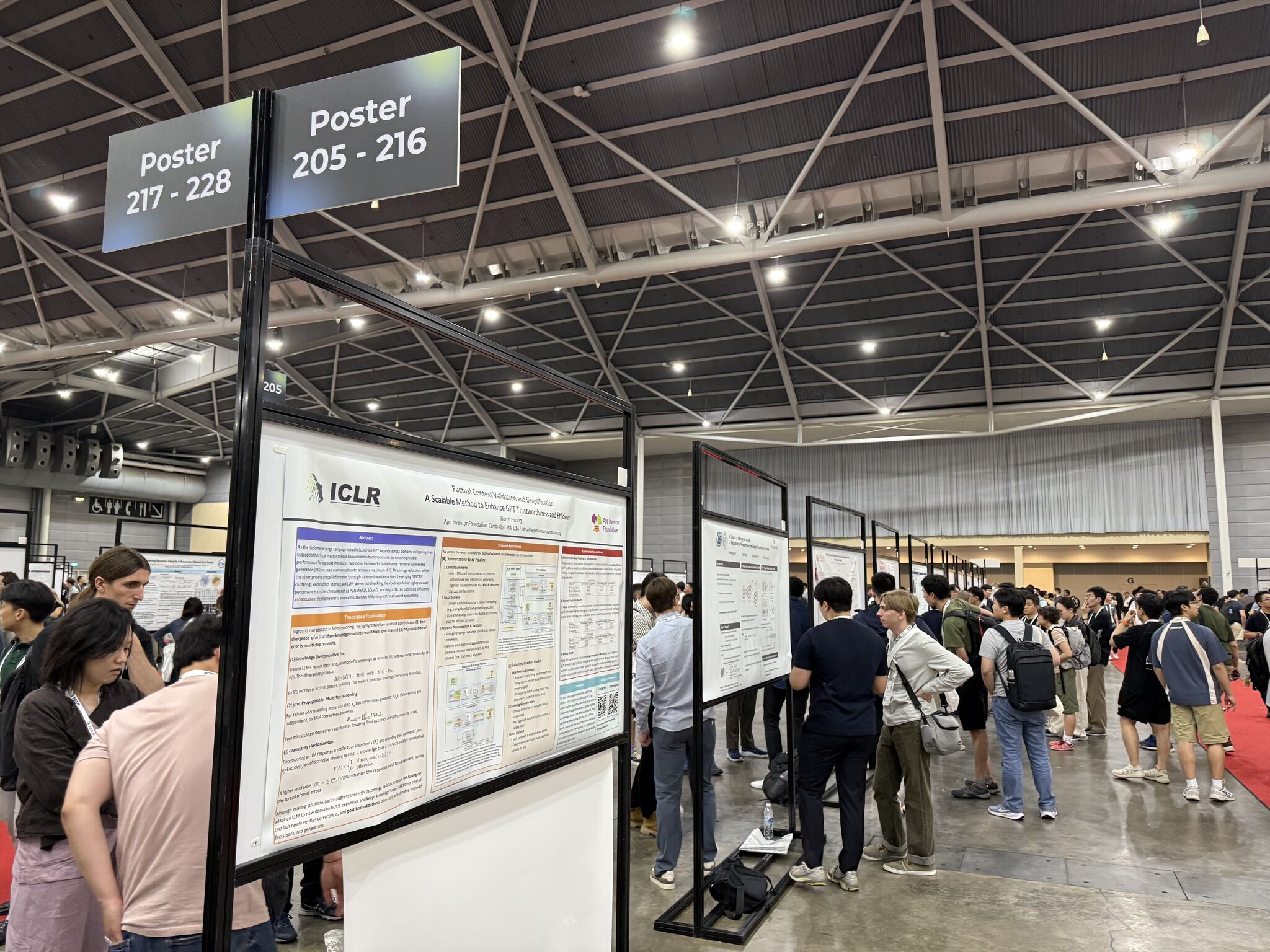 Attendees discussing research during the main poster session at ICLR 2025.