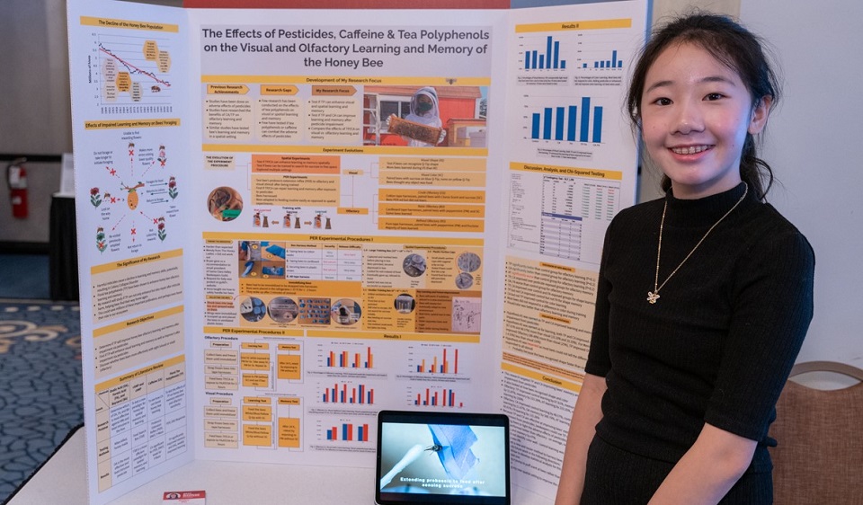 Rory Hu beside her honeybee research poster at Broadcom MASTERS
