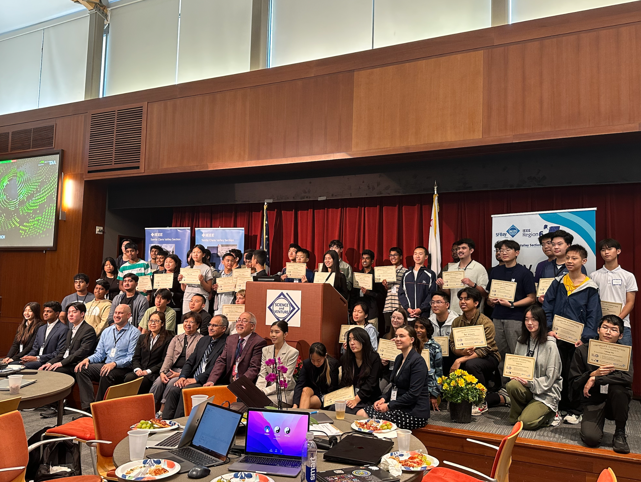 Workshop participants gathered on stage with certificates beside IEEE, SV Young Scholars, and ACM banners